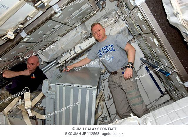 It's another moving day onboard the International Space Station, as NASA astronauts Scott Kelly, left, Expedition 26 commander, and Eric Boe