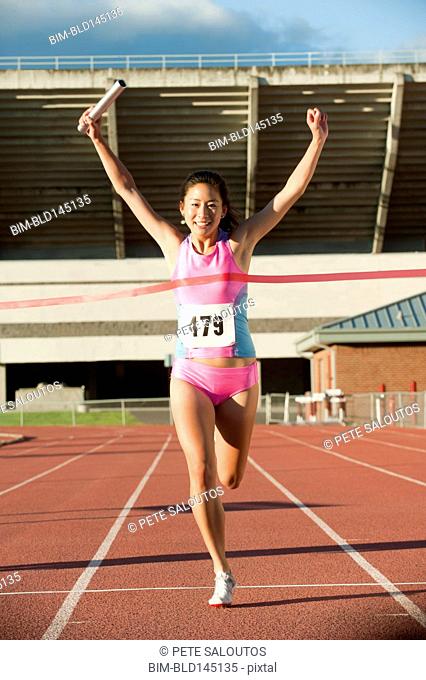 Japanese runner with baton winning race