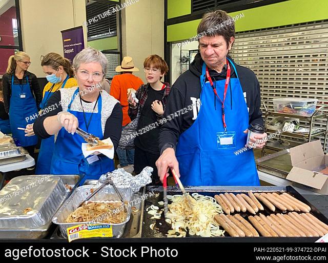 21 May 2022, Australia, Sydney: Election workers fry sausages outside a polling station at the International Grammar School on Kelly Street in Sydney, Australia