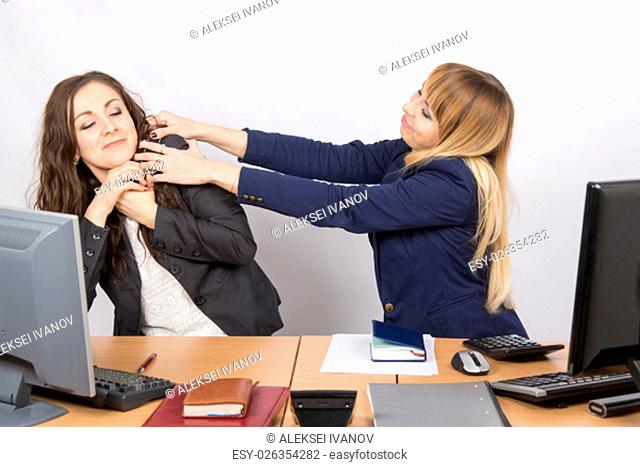 Two young pretty business woman sitting at a office table is divided into two jobs