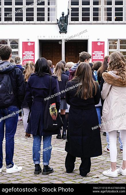 18 October 2021, Baden-Wuerttemberg, Heidelberg: First-year students stand in front of the New University building during a welcome event on University Square