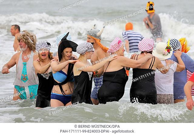 The ""Rostock Seals"" walking in costumes into the 10-degree Celsius waters of the Baltic Sea during the start of the ""fifth season"" at 11:11 in Rostock