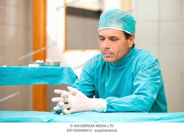 Thoughtful surgeon sitting in a operating room in a hospital