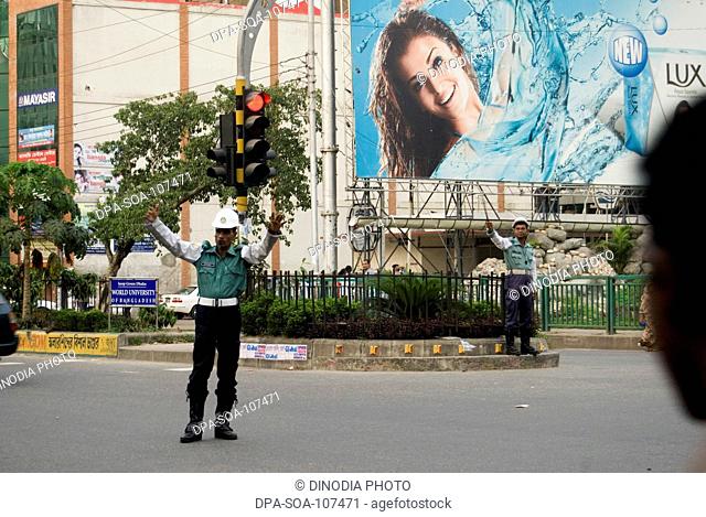Traffic Police Controlling Traffic On Street and Aishwarya Rai Hoarding at Road crossing ; Dhaka ; Bangladesh