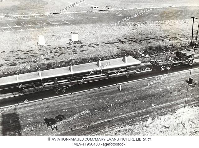 The Huge, 74 Feet Long, Wooden Wing-Flap Sub-Assembly of the Hughes H-4 Hercules / Spruce Goose on a Transporter Trailer Being Towed Along a Highway Between the...