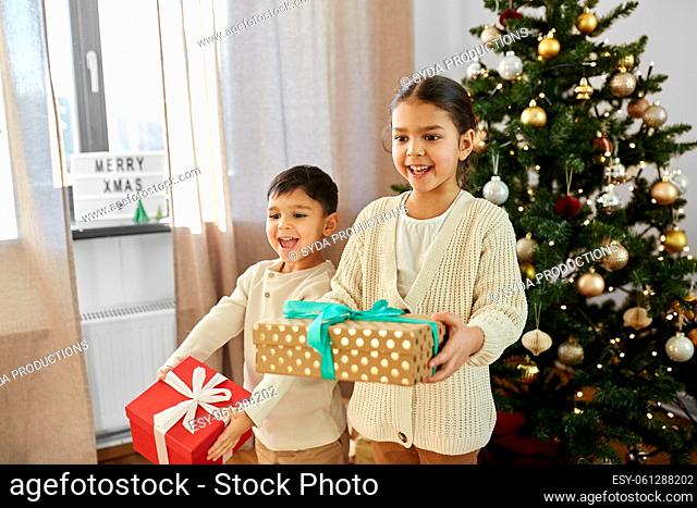 happy children with christmas gifts at home