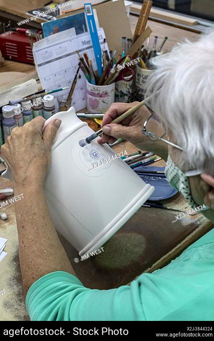 Holland, Michigan - An artist paints Delftware at the De Klomp Wooden Shoe and Delft Factory, part of the Veldheer Tulip Farm
