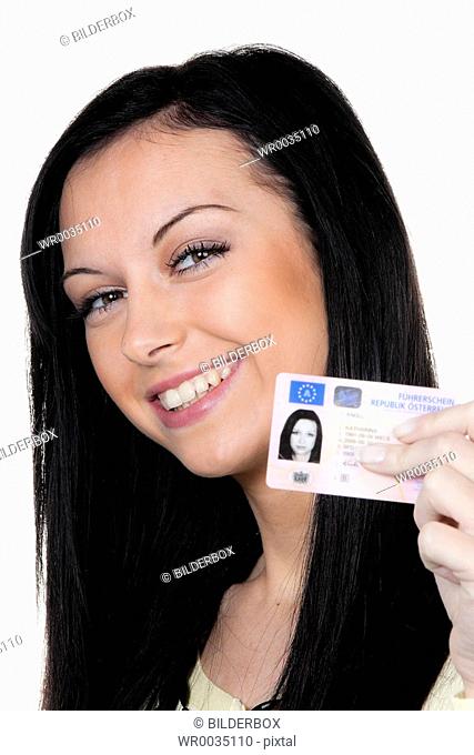 Woman with car keys and drivers license. Driving test