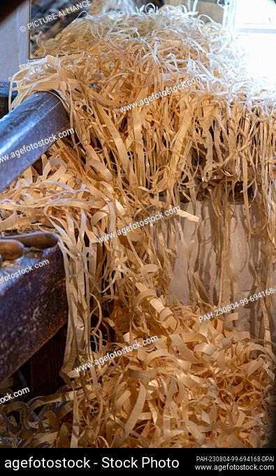 PRODUCTION - 27 July 2023, Saxony, Seiffen: Spruce shavings lie in front of a workbench in the historic turning mill in the Seiffen Open-Air Museum
