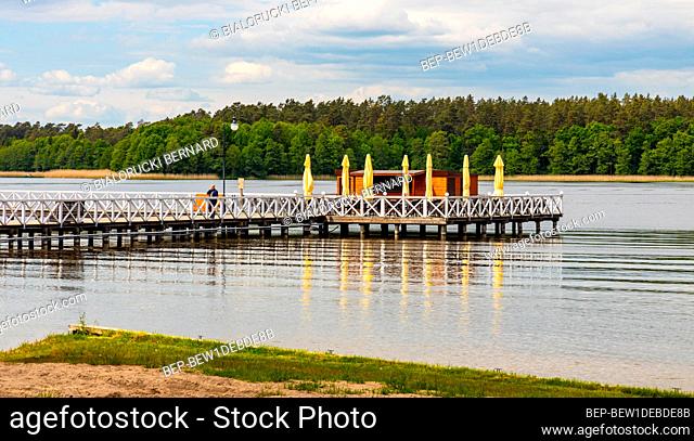 Augustow, Poland - June 1, 2021: Jetty pier and public beach at Necko lake shore in Masuria lake district resort town of Augustow in Podlaskie voivodship