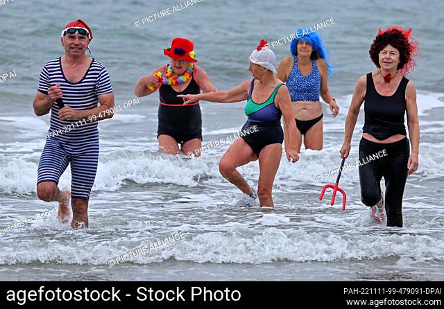 11 November 2022, Mecklenburg-Western Pomerania, Warnemünde: The members of the ""Rostocker Seehunde"" ice bathing club come out of the eleven-degree Baltic Sea...