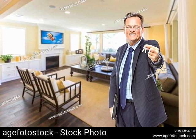 Smiling Male Real Estate Agent Handing Over Keys Standing in Beautiful Living Room