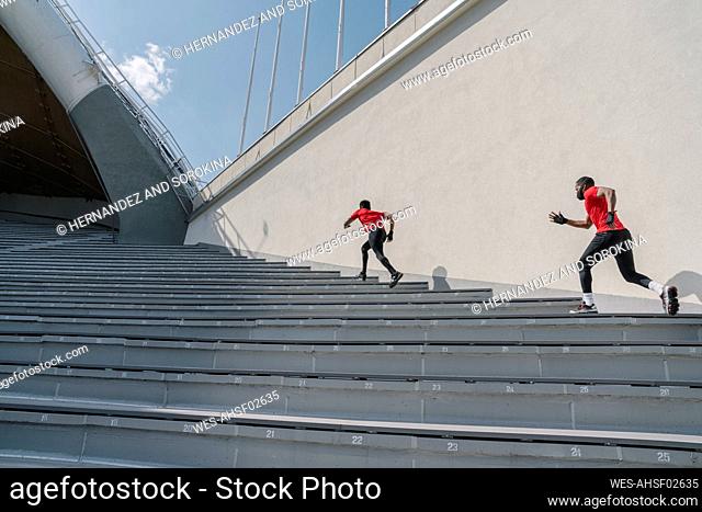 Sportsmen wearing face masks running up stairs