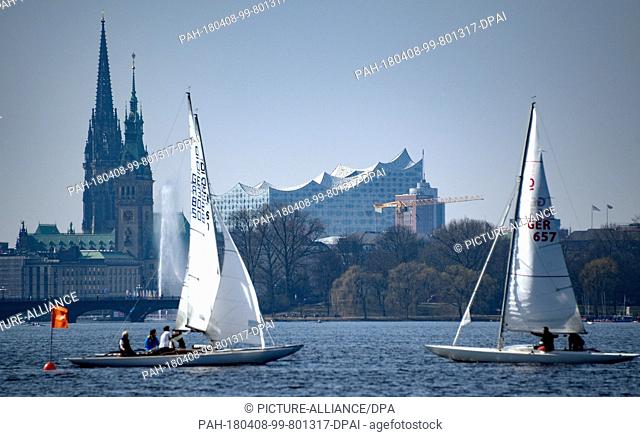 dpatop - 08 April 2018, Germany, Hamburg: Sailing boats on the Outer Alster lake in sunny weather. The Elbe Philharmonic Hall can be seen in the background