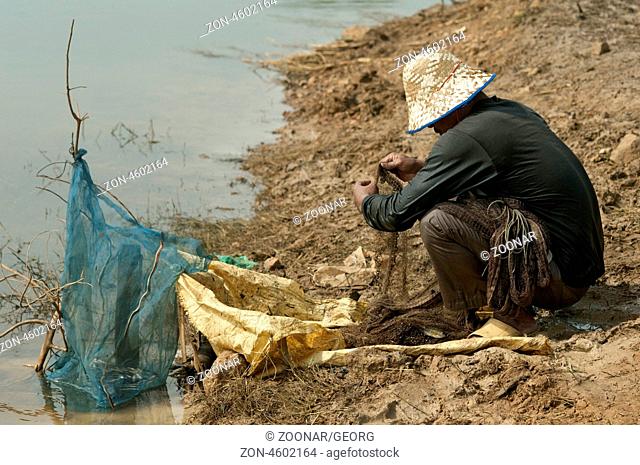 Fischer bereitet sein Wurfnetz vor, Battambang, Kambodscha / Fisherman preparing his cast net for fishing, Battambang, Cambodia