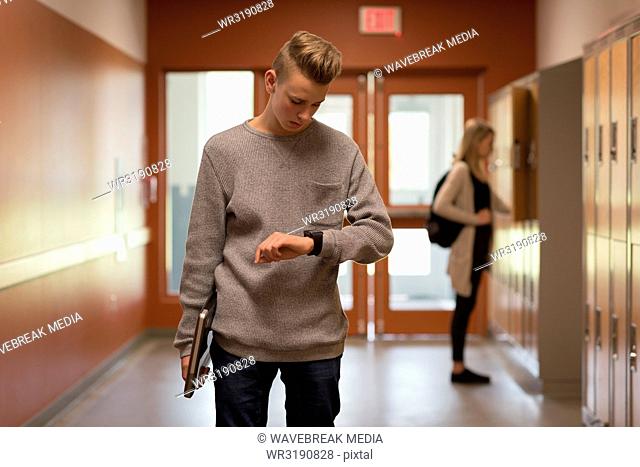 Teenage boy checking time on smartwatch