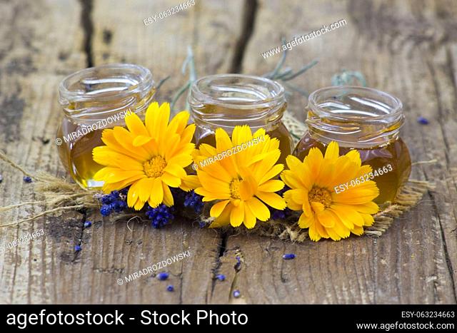 honey and calendula flowers on old wooden background