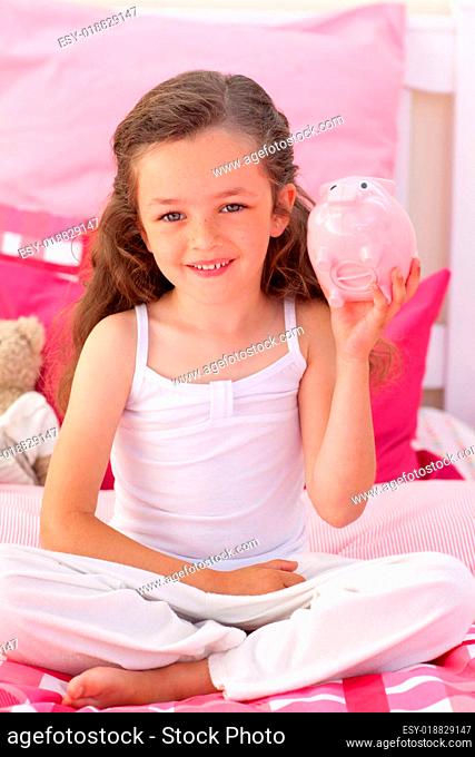 Smiling girl holding a piggybank