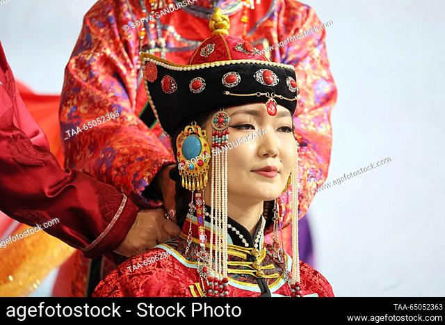 RUSSIA, MOSCOW - NOVEMBER 21, 2023: Bride Belekmaa Ondar performs the Dugdeeri rite (ceremony of braiding the bride’s hair) during a wedding ceremony according...