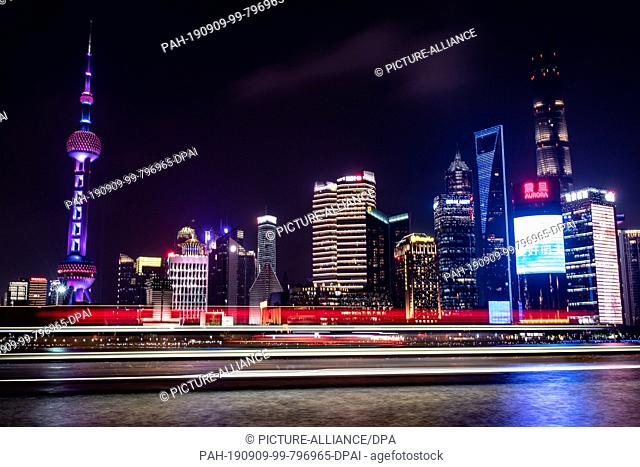 08 September 2019, China, Shanghai: View from the promenade ""The Bund"" at the Huangpu river to the illuminated skyline of the special economic zone Pudong...