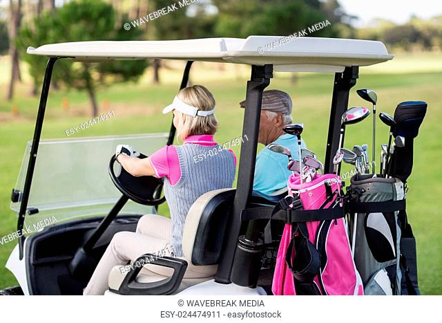 Mature woman driving golf buggy