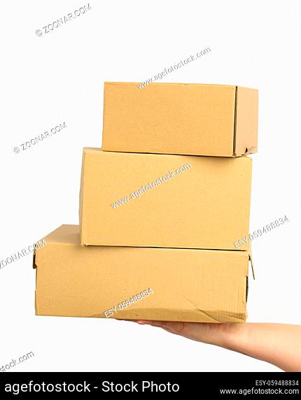 hand holds a brown cardboard box of paper on a white isolated background, moving concept