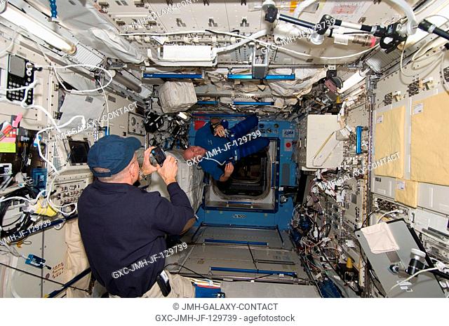 NASA astronaut Don Pettit (foreground), Expedition 30 flight engineer, photographs European Space Agency astronaut Andre Kuipers, flight engineer