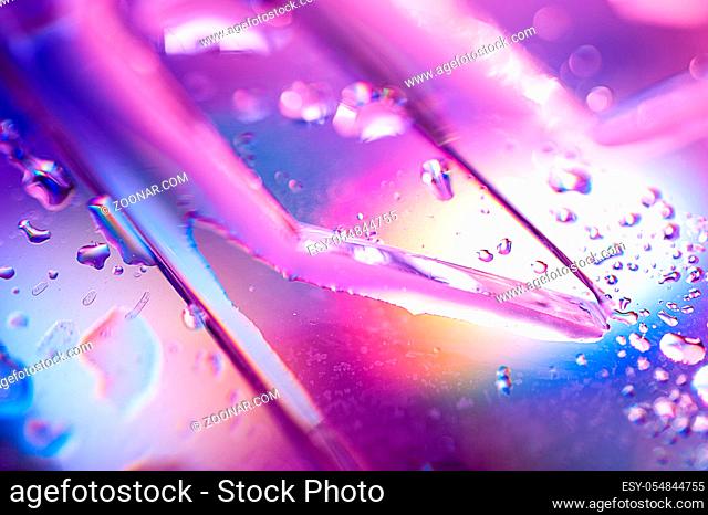 Abstract trendy holographic background in the style of the 80-90s. Real texture of broken glass or ice and water drops in bright acid colors