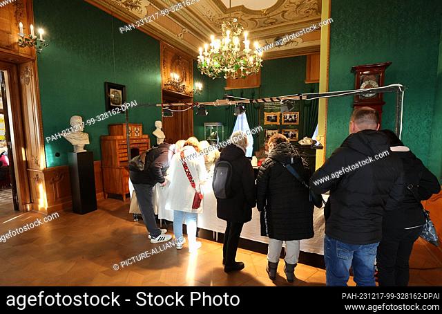 17 December 2023, Thuringia, Greiz: Visitors stand at stalls in the Lower Castle at the ""Romantic Princes' Christmas"". Visitors experience a Christmas journey...