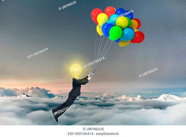 Concept of freedom. A businessman being lifted by balloons with glowing light bulb a head. Concept of idea