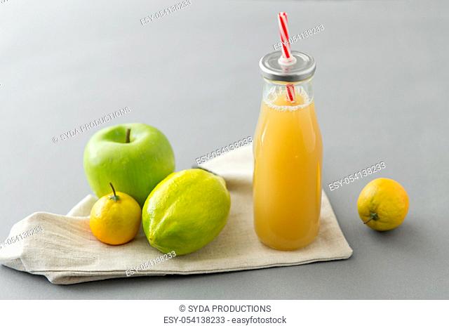 reusable glass bottle of fruit juice with straw