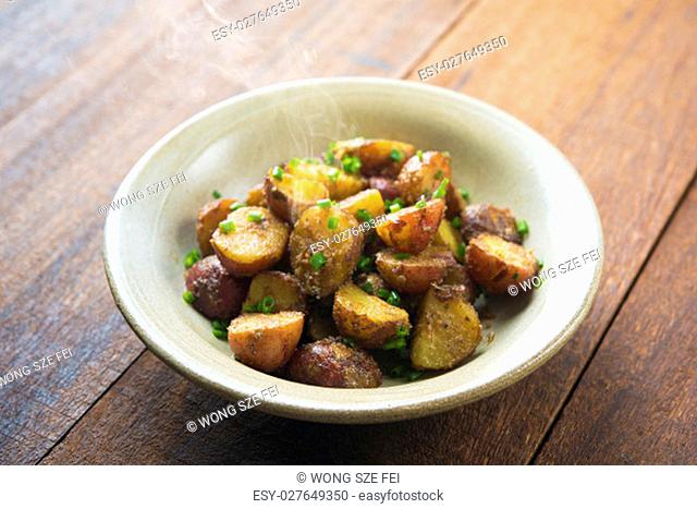 Freshly oven roasted baby potatoes with skin on wooden table