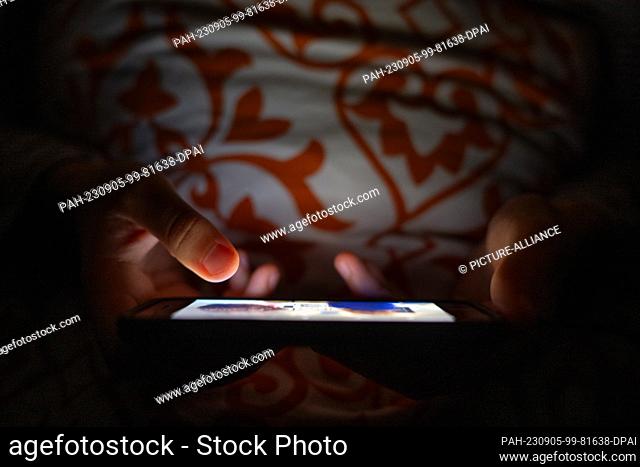 PRODUCTION - 01 September 2023, Berlin: A woman is watching a program on a smartphone in a bed. Photo: Sebastian Christoph Gollnow/dpa