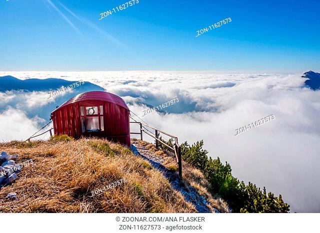 Bivacco Dino bivouac with the sea of clouds under. The Alps, Italy