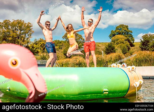 Friends having fun jumping off a big tuby thingy thing in public pool