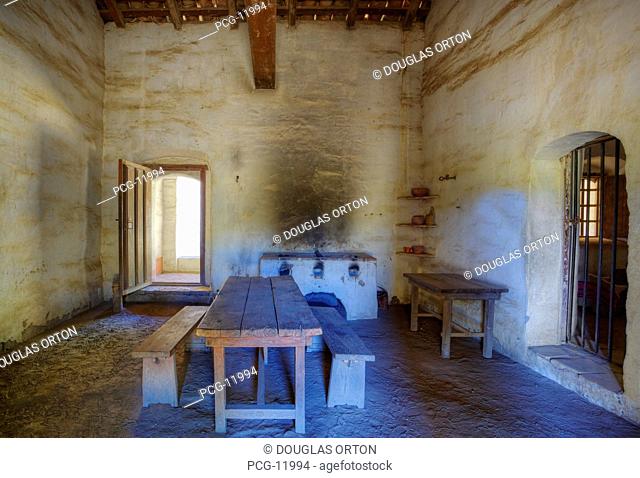 Kitchen with wood fired adobe stove and rough hewn table, dirt floor and adobe walls with officer's apartment in background at Mission La Purisima State...