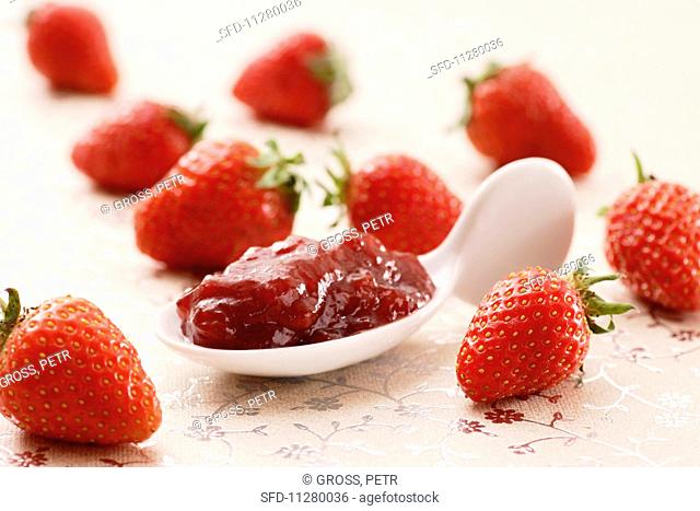 A spoonful of strawberry jam and fresh strawberries