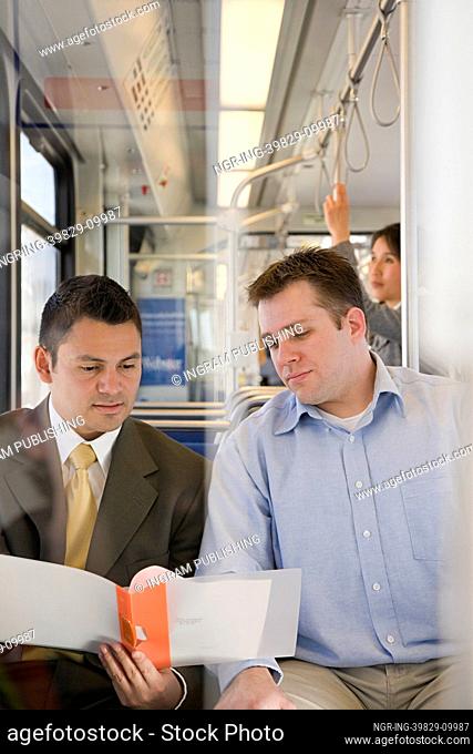 Men looking at file on train