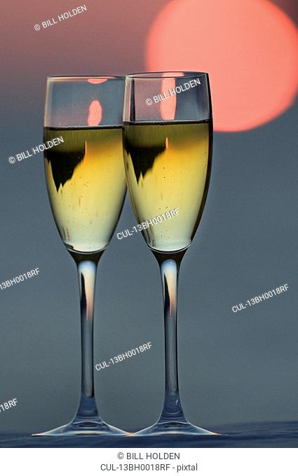 Two glasses of champagne at sunset