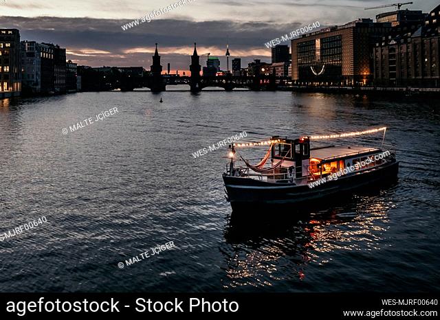 Illuminated boat on river at dusk