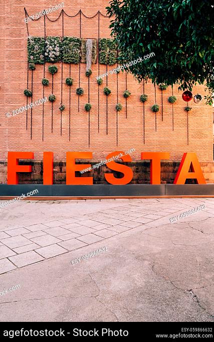 Barcelona, Spain - 18 DECEMBER 2019: FIESTA inscription in large red letters against background of a brick wall