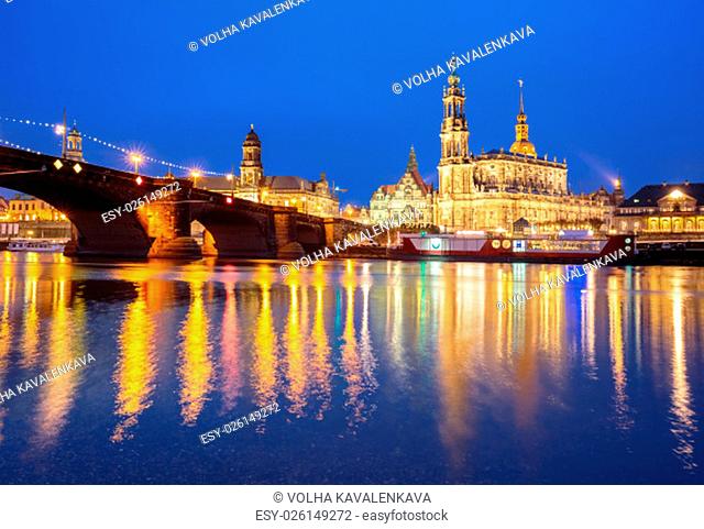 Dresden Cathedral of the Holy Trinity aka Hofkirche Kathedrale Sanctissima Trinitatis and Augustus Bridge with reflections in the river Elbe at night in Dresden