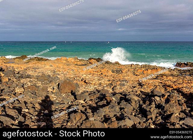 Lava rocks, rough sea and water waves at the coastline of Costa Teguise on Canary island Lanzarote, Spain