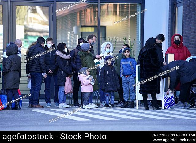 08 March 2022, Hamburg: Ukrainian refugees stand in front of the Office for Migration on Hammer Straße in the Wandsbek district, waiting to be admitted