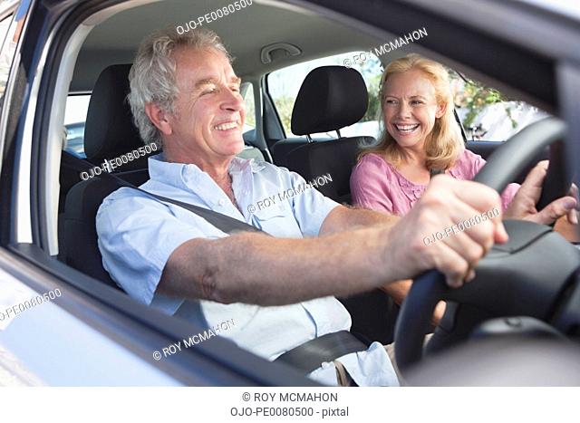 Smiling couple driving in car