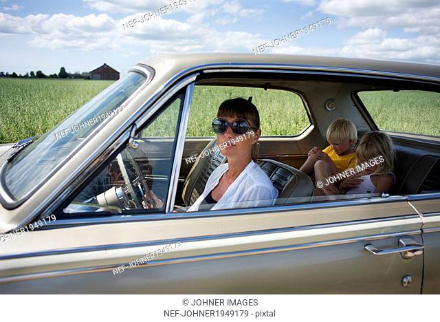 A woman and her children in a car
