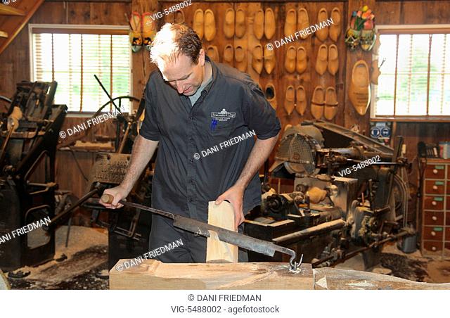 NETHERLANDS, ZAANSE SCHANS, 16.07.2014, Craftsman shaping a block of wood to make traditional Dutch wooden shoes in the small town of Zaanse Schans, Holland
