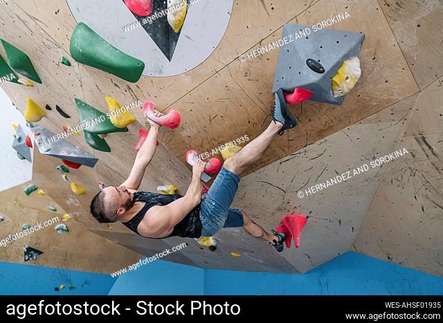Man bouldering in climbing gym