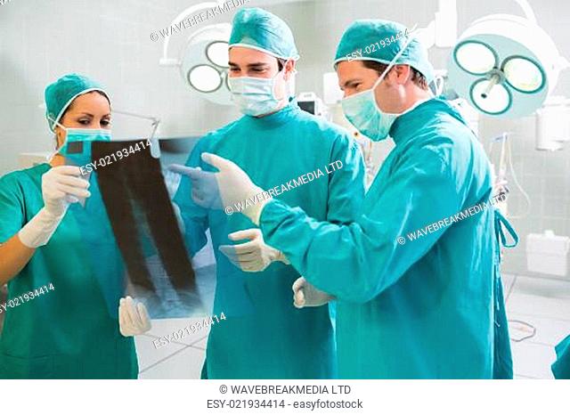 Close up of a surgical team analysing a X-ray in an operating theatre