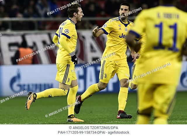 Juventus' Federico Bernardeschi (L) cheers with his teammate Sami Khedira after his score during the Champions League group match between Olympiacos Piraeus and...